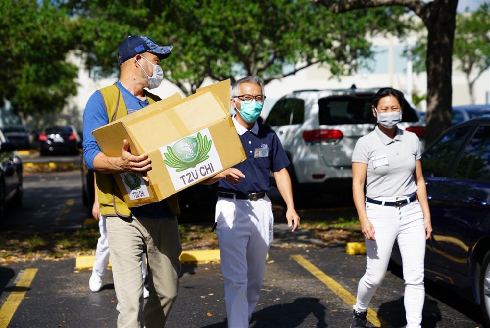 BD Foundation and Tzu Chi volunteers carrying boxes of PPE for delivery