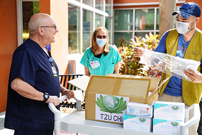 Handoff of masks and supplies to healthcare workers at Memorial Hospital